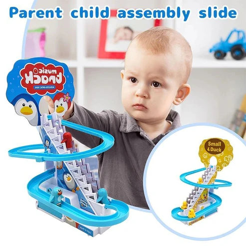 Product packaging box for Music Track Acousto-Optic Toy next to the fully assembled penguin climbing stairs slide toy with cheerful cartoon penguin graphics