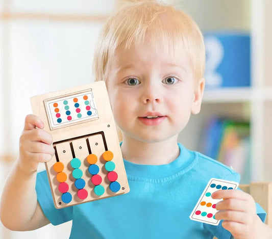 Montessori wooden sliding logic puzzle toy held by a blonde toddler boy.