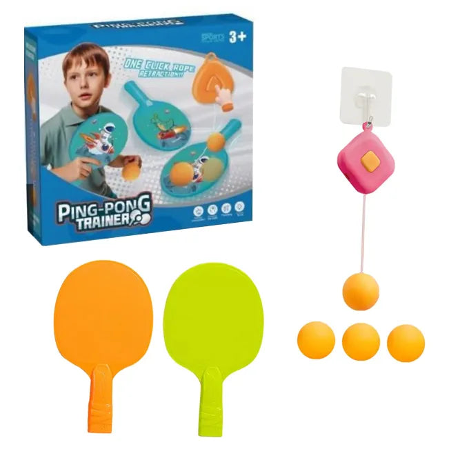 Retail packaging and components box of the pink square-shaped hanging ping pong trainer set, showing two paddles and three orange balls next to a wall-mounted hook.