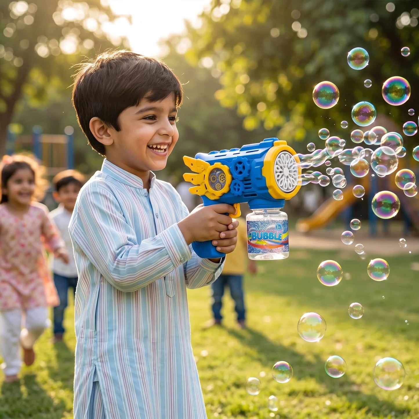 Young children chasing colorful bubbles from a handheld bubble blaster machine during a summer outdoor birthday party