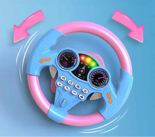 Promotional banner for the pastel pink and blue multifunctional simulation steering wheel toy, displayed against a bright blue sky background with clouds and a mini toy car on a road graphic.